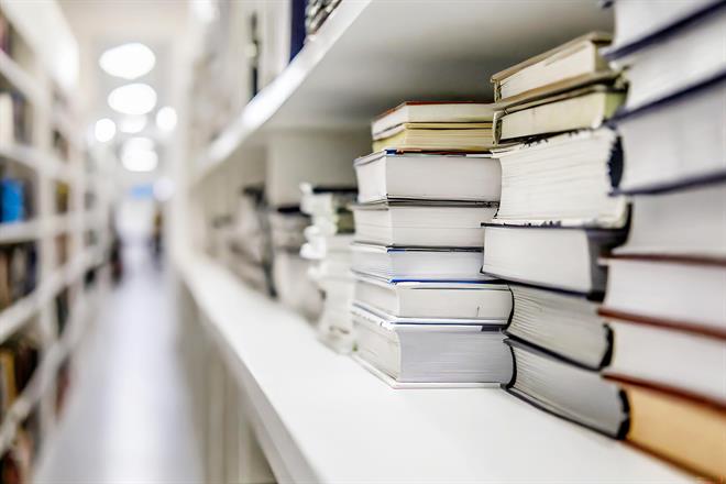 Rows of books in piles in a library