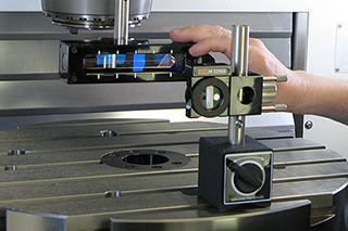 Magnetic base sitting on machine bed with machine engineer performing a test