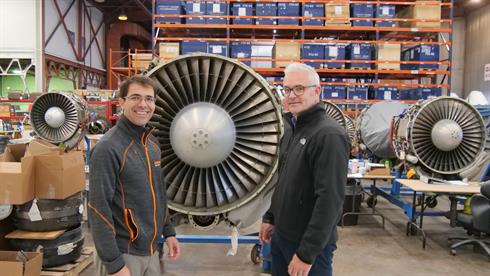 Tronosjet case study - two people standing in front of a jet engine, inside the facility.