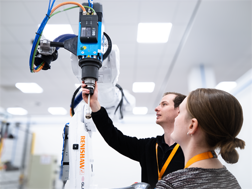 Two engineers looking at RCS product on industrial robot