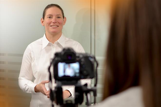 Female engineer speaking in front of a camera which you can see is filming her